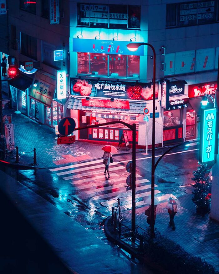 Tokyo street at night with colorful neon lights and wet pavement, capturing the surreal cityscape of Japan in the rain.