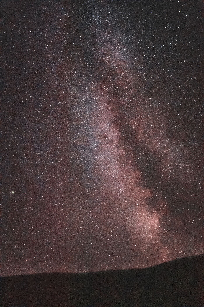 Starry night sky with the Milky Way visible above the silhouette of the Ukrainian Carpathians mountains range.