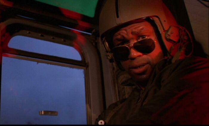 Actor in a pilot helmet and sunglasses inside a helicopter highlighting Easter eggs and hidden details from popular films.