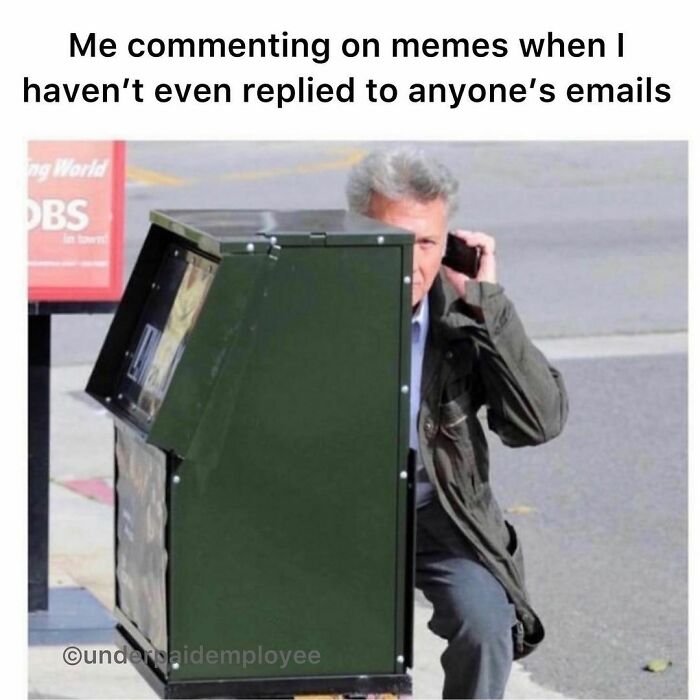 Man hiding behind a mailbox, humorously captioned about underpaid employees neglecting emails.
