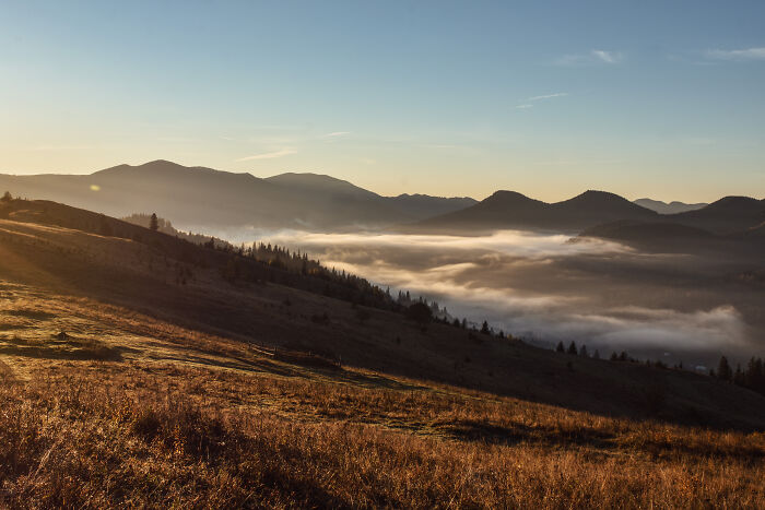 Sunrise over misty valleys and rolling hills in the Ukrainian Carpathians showcasing breathtaking natural beauty.