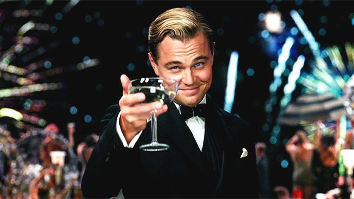 Leonardo DiCaprio holding out the glass of beverage