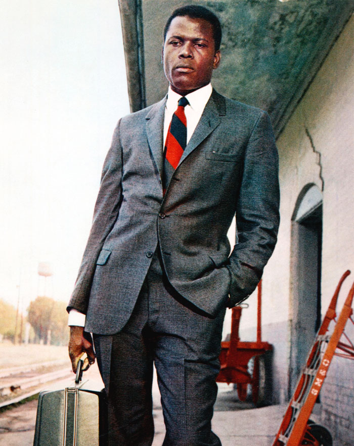 Sidney Poitier in a costume with a suitcase