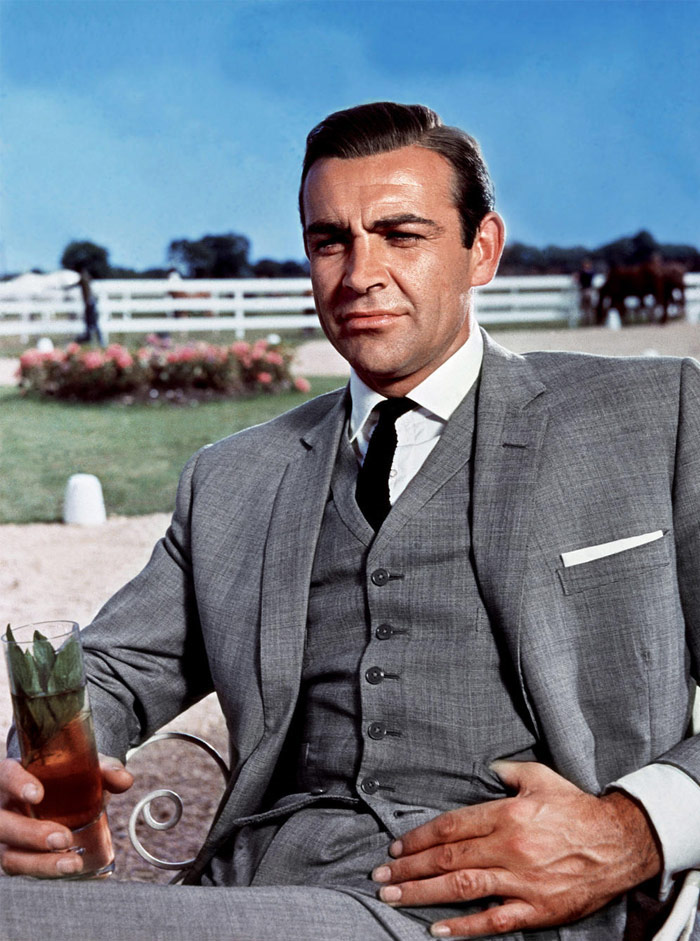 Sean Connery in a costume sitting in the chair with a glass of lemonade
