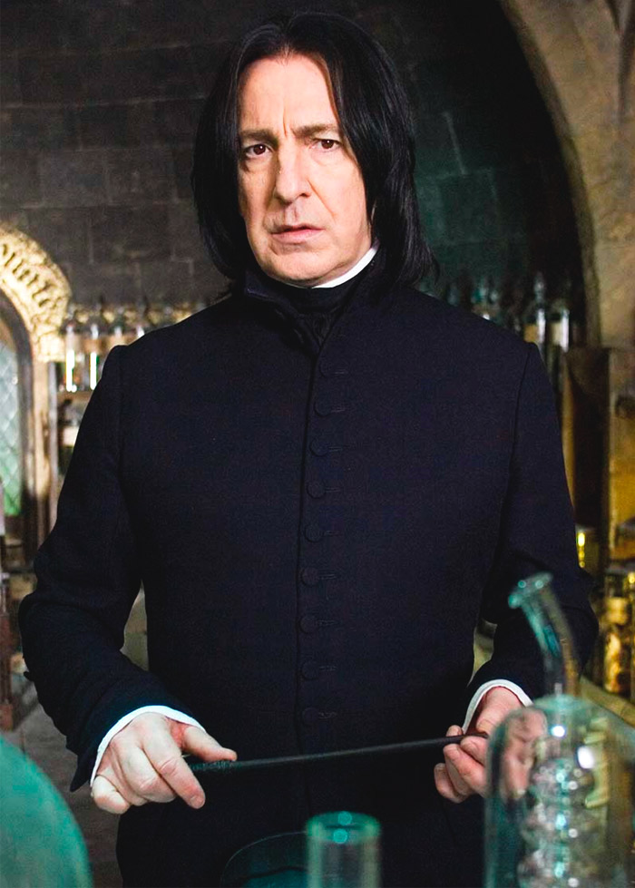 Alan Rickman in a black costume with a stick in his hands