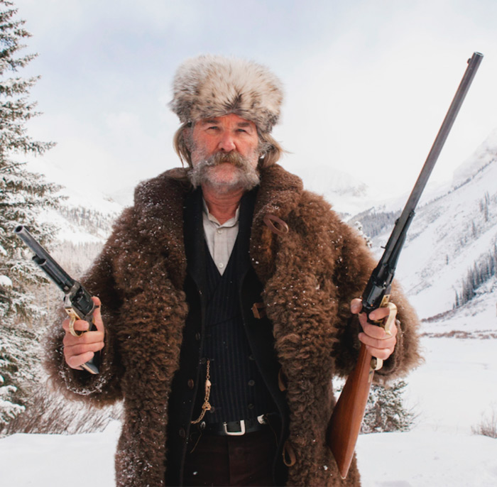 Kurt Russell with guns on the snowy background
