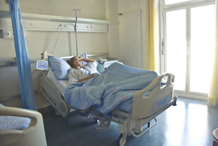 Patient resting in a hospital bed with medical equipment nearby, illustrating experiences of people who came back to life.