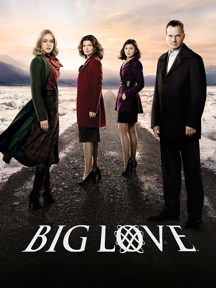 Cast of HBO's "Big Love" standing on a snow-covered road, wearing winter coats.