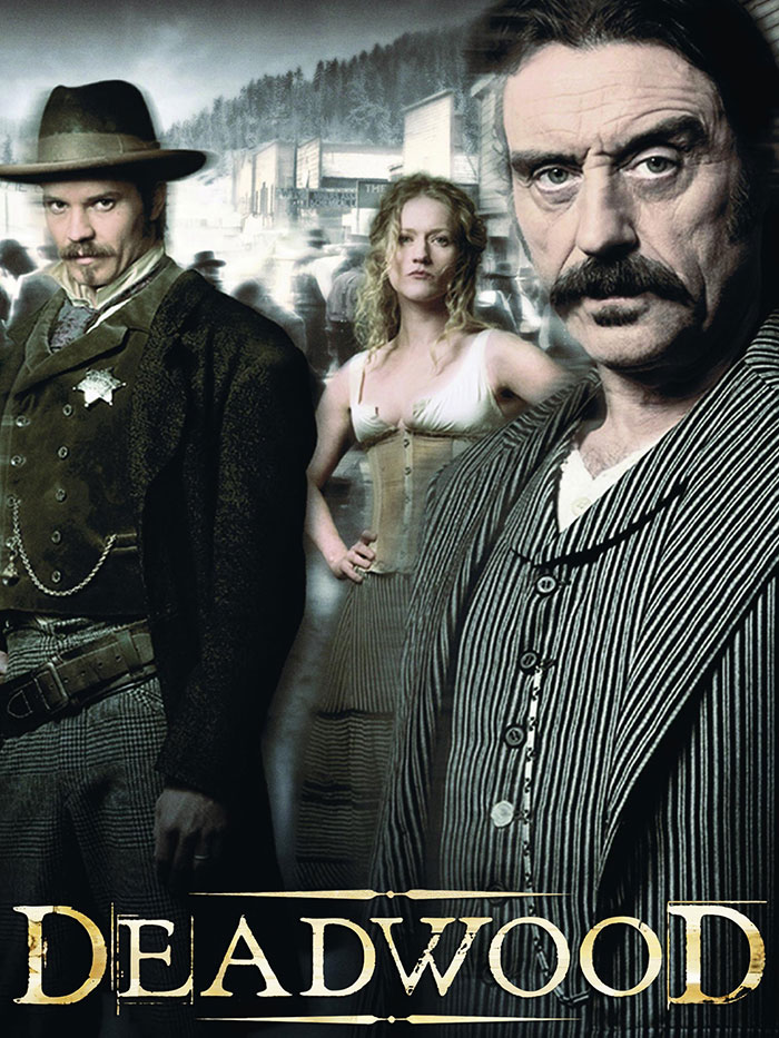 Deadwood characters in period attire, set in a historic Western town scene.