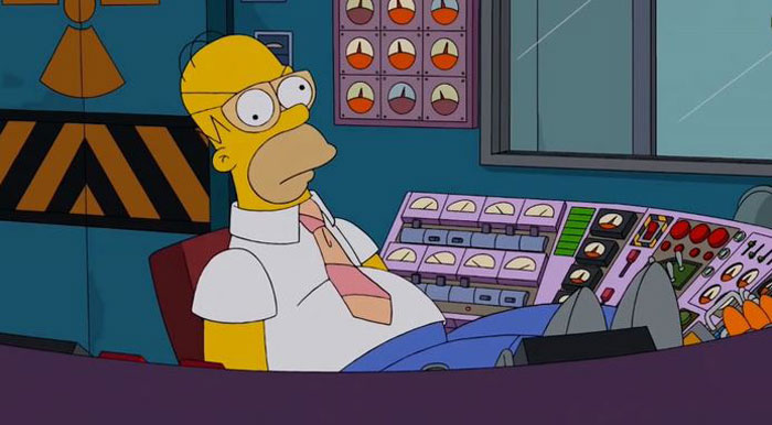 Homer Simpson sitting relaxed at a control panel, depicting details fans noticed in The Simpsons show theories.