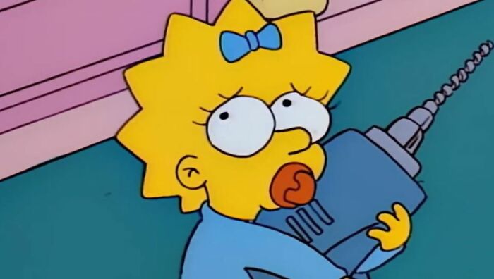 Maggie Simpson holding a large drill, a small detail fans noticed in The Simpsons theories about Homer.