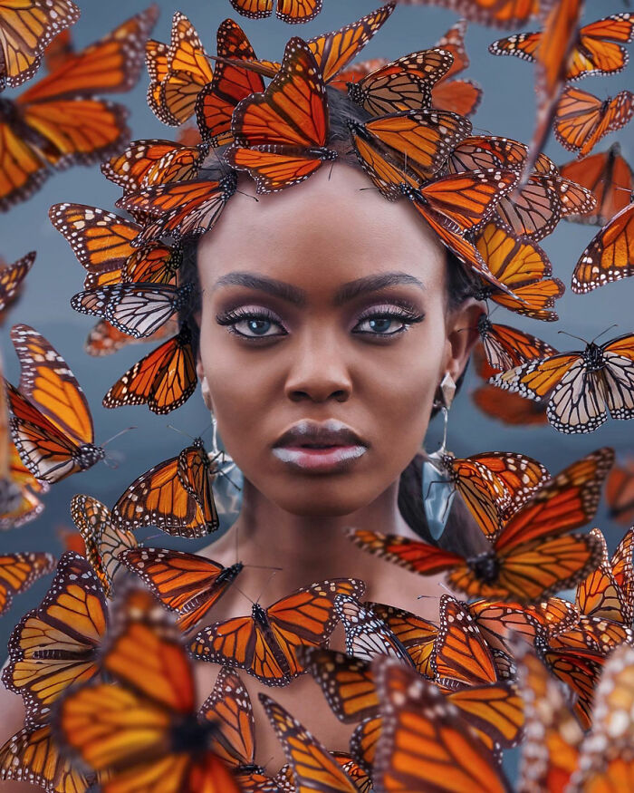 Woman surrounded by vibrant Monarch butterflies, highlighting the beauty of the Monarch Butterfly Biosphere Reserve in Mexico.