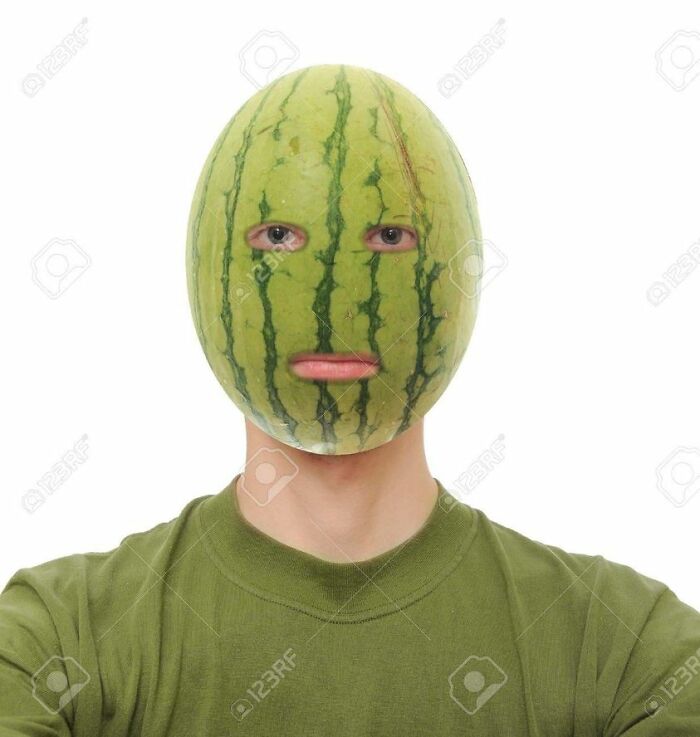 Person with watermelon mask, wearing a green shirt, against a white background. Weird stock image concept.
