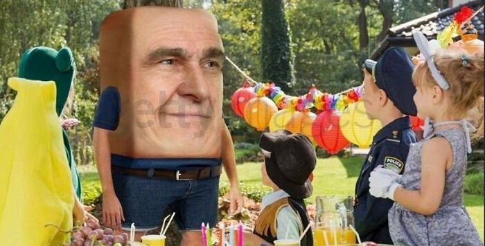 A surreal stock image of a man with a cube head at a colorful outdoor children’s party, embodying the weirdest stock photo theme.