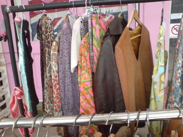 Clothing rack filled with various dresses and jackets, illustrating common scams in fashion resale and thrift shopping.