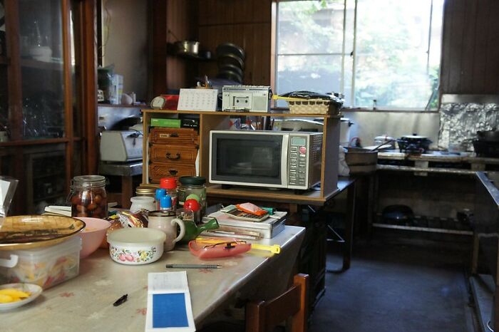 Cluttered kitchen with microwave, jars, utensils, and various items, illustrating common household scams unnoticed by many.