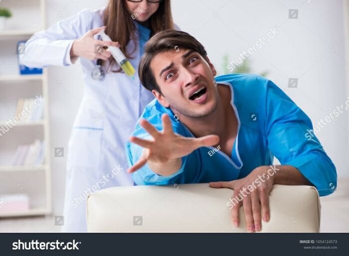 Man in blue shirt reaching out dramatically, woman behind holding a syringe, illustrating a weird stock image scenario.
