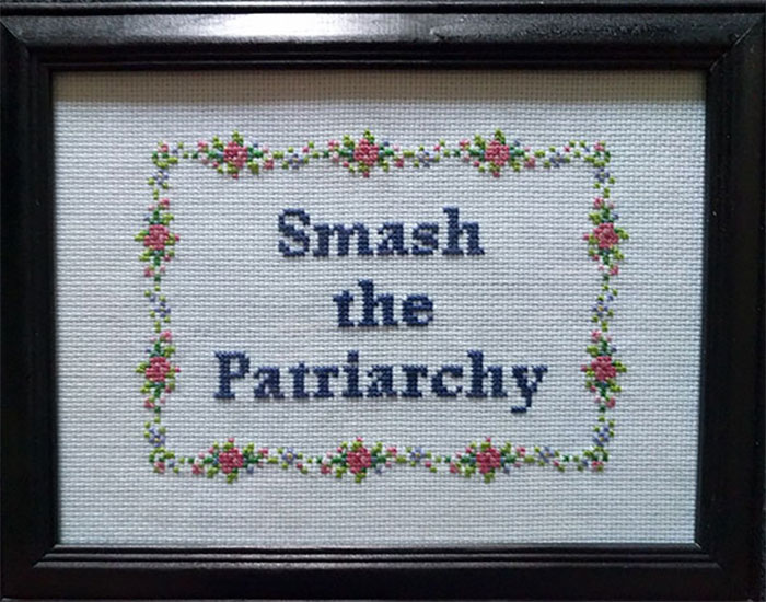 Embroidered cross-stitch with floral border displaying the phrase smash the patriarchy, highlighting strong mothers-in-law.