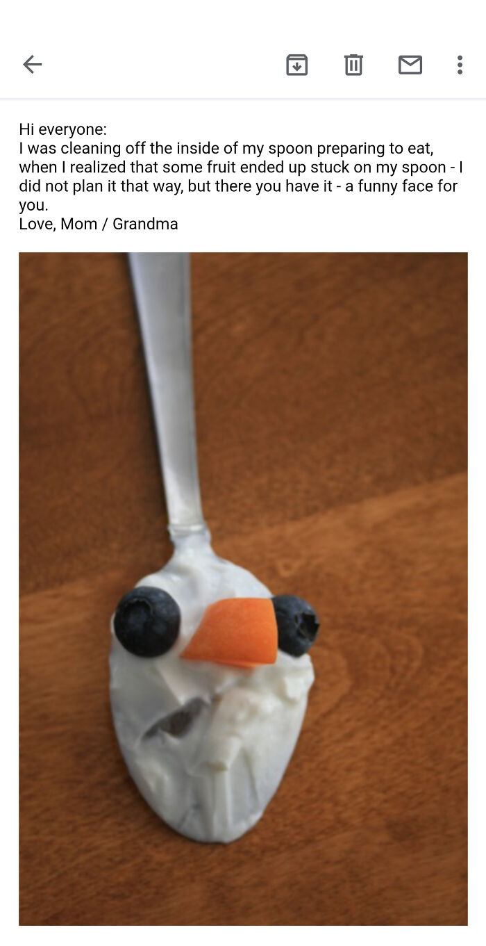 Spoon with fruit and yogurt forming a funny face, shared by a loving mother-in-law showing kindness and humor.