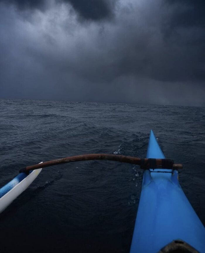 View from a kayak on dark, choppy ocean waters under stormy skies triggering thalassophobia and fear of deep waters.