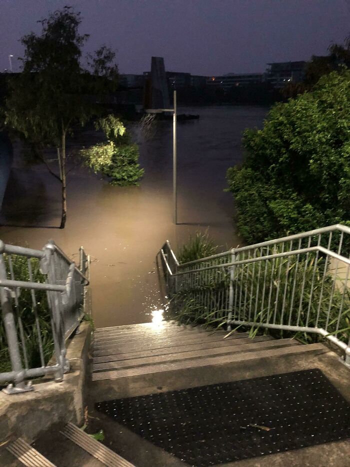 Staircase leading into dark murky water at night, evoking deep waters and triggering thalassophobia fear.