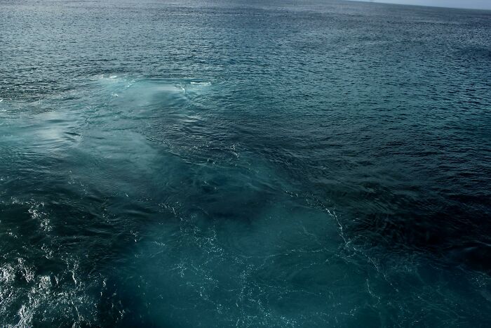Deep dark ocean water with swirling currents, evoking thalassophobia and fear of the vast unknown depths.