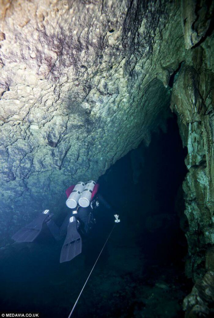 Scuba diver exploring a dark underwater cave, triggering thalassophobia and fear of deep waters.