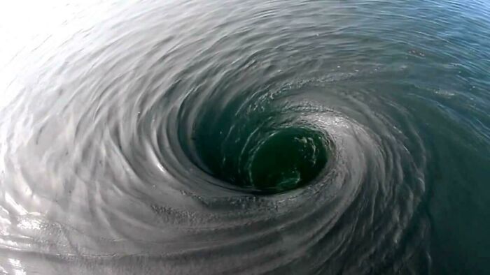 Dark swirling whirlpool in deep water creating a vortex, evoking fear of deep waters and thalassophobia.