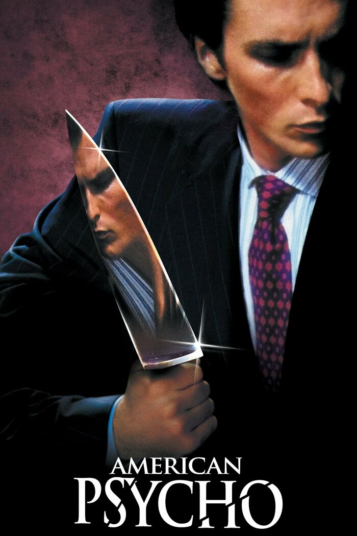 Man in a suit holding a sharp knife with his reflection visible, representing horror comedies with dark humor.