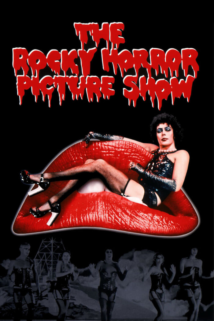 Iconic scene from The Rocky Horror Picture Show showcasing horror comedy with characters in dramatic costumes on a dark background.