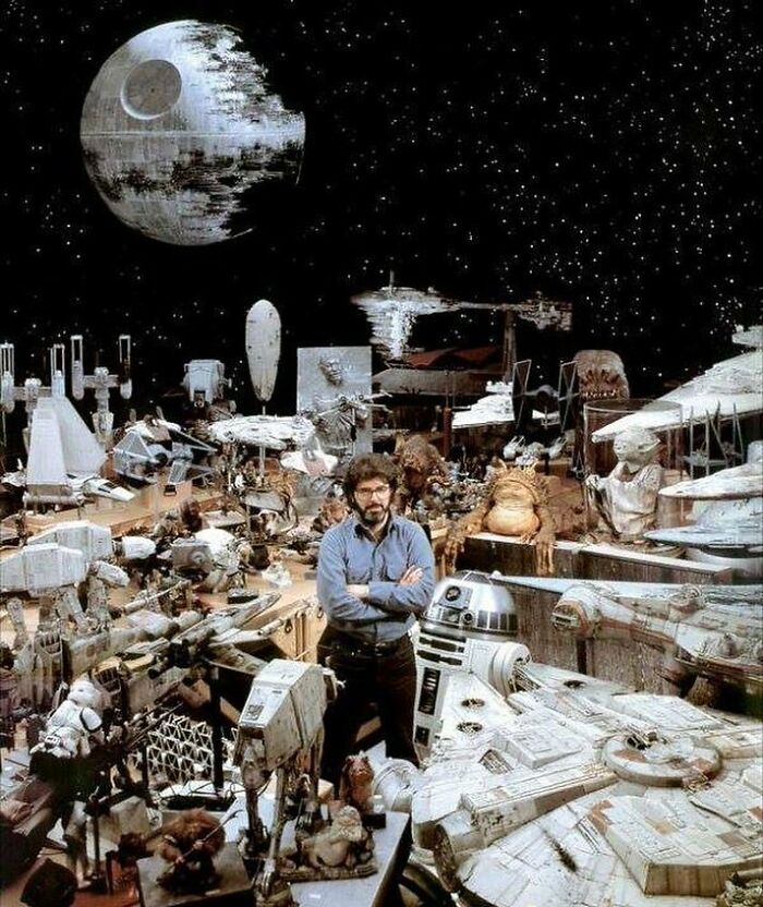 George Lucas Surrounded By Star Wars Props