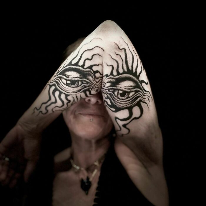 Genius tattoos of eyes on elbows creating an illusion with arm movement.