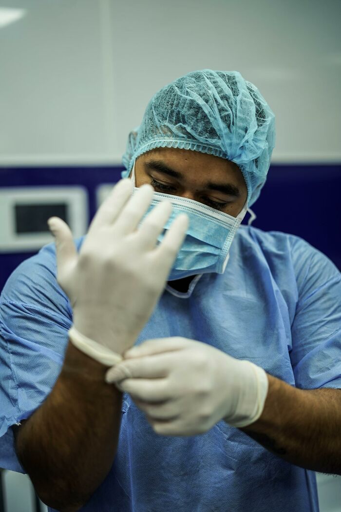 Surgeon wearing scrubs and mask preparing for surgery, highlighting bone-chilling stories of patients waking up during surgery