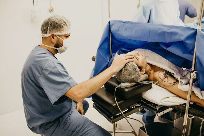 Surgeon comforting patient during surgery in operating room, highlighting bone-chilling stories of waking up during surgery.