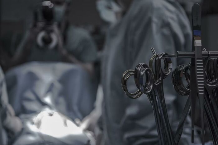 Surgical instruments lined up with surgeons in the background during a procedure illustrating surgery awareness stories.