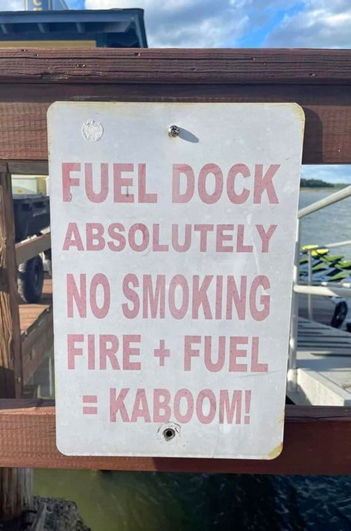 Hilarious and absurd sign at fuel dock warning no smoking due to fire and fuel risk with kaboom humor