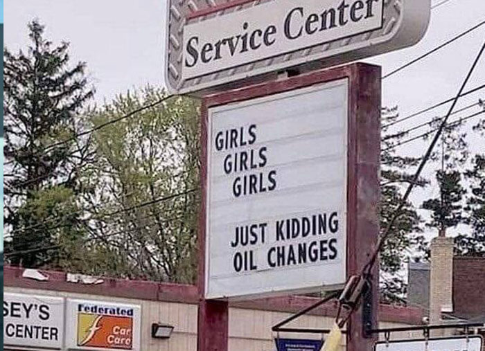 Hilarious and absurd sign at a service center reading girls girls girls just kidding oil changes, spotted and shared online.