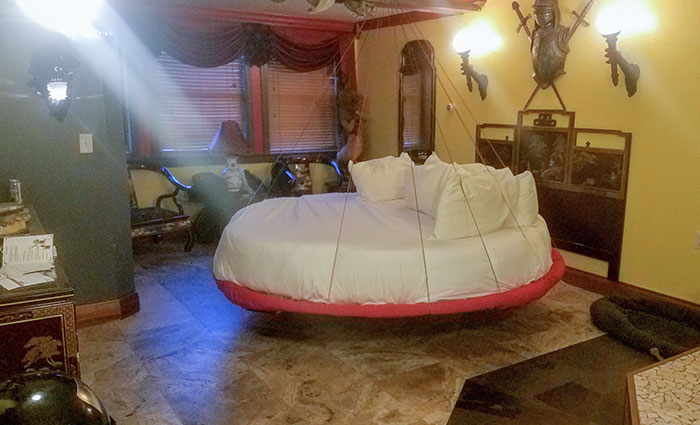A Hotel Room With A Swinging Bed Suspended From The Ceiling