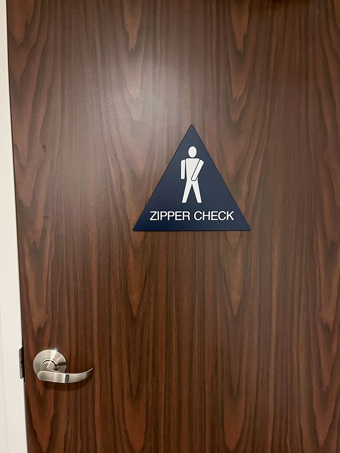 This Zipper Check Sign On The Backside Of The Door Of A Hotel’s Lobby Bathroom