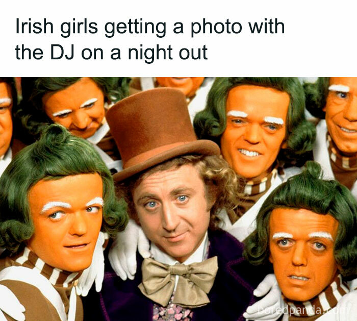 Group of people dressed as orange-faced Oompa Loompas posing with a man in a top hat, showcasing Irish humor online.