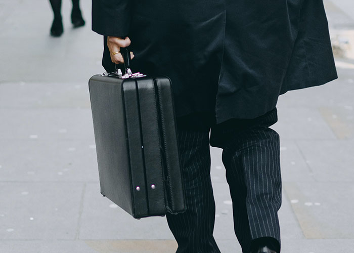 Person in a suit carrying a briefcase, symbolizing ways to become a millionaire.