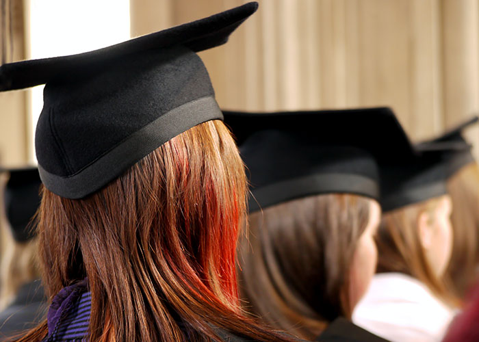 People wearing graduation caps, symbolizing success and paths to becoming millionaires.