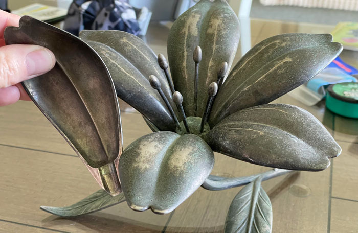 This Metal Decorative Floral Piece, Removable Petals, 10” Long, On A Table Top