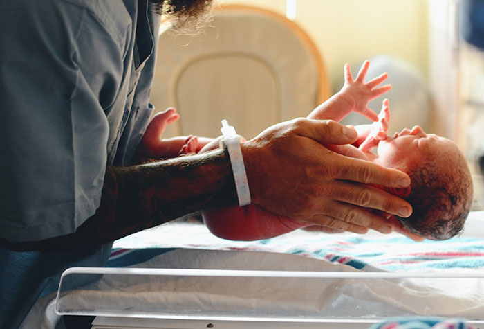 Nurse holding a newborn baby in her hands 