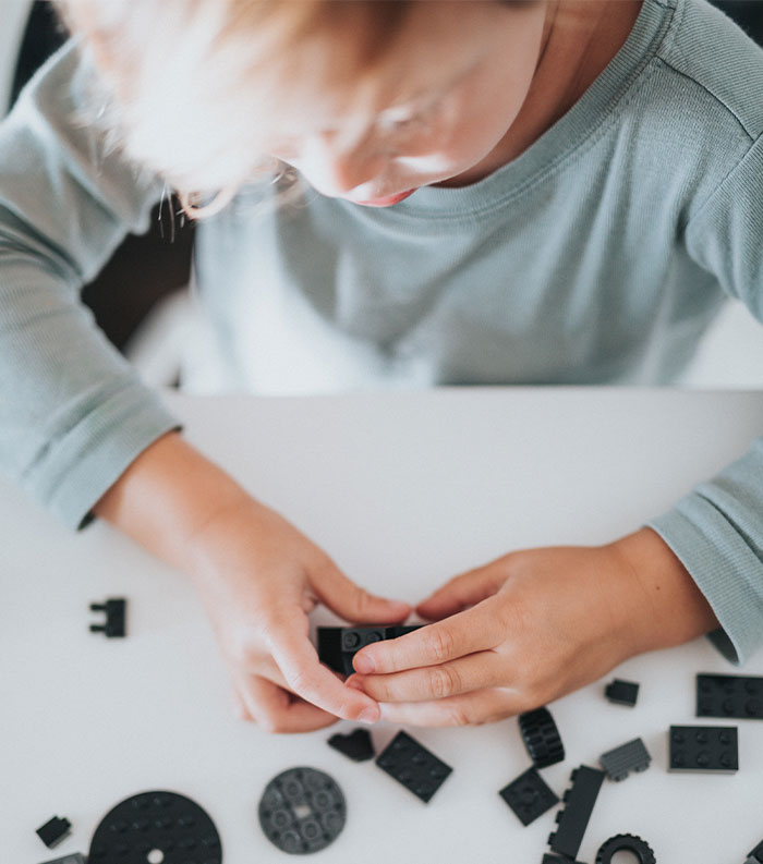 Boy collecting black LEGO's 
