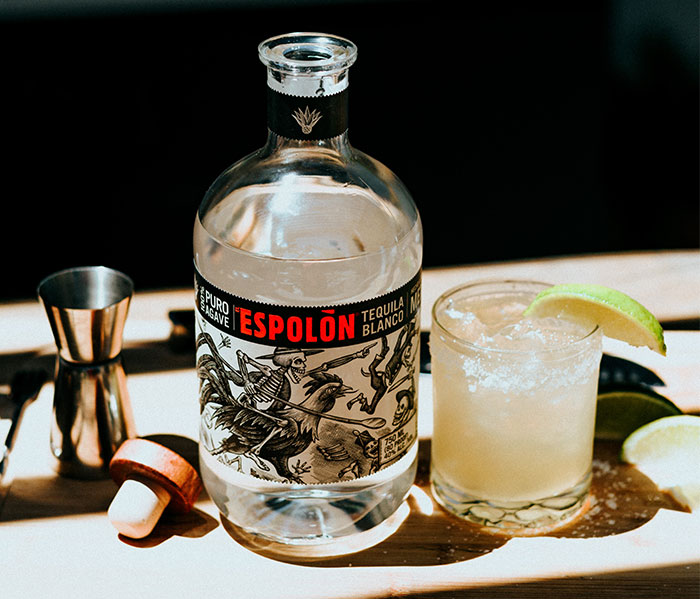 Tequila bottle glass and lime on a table 