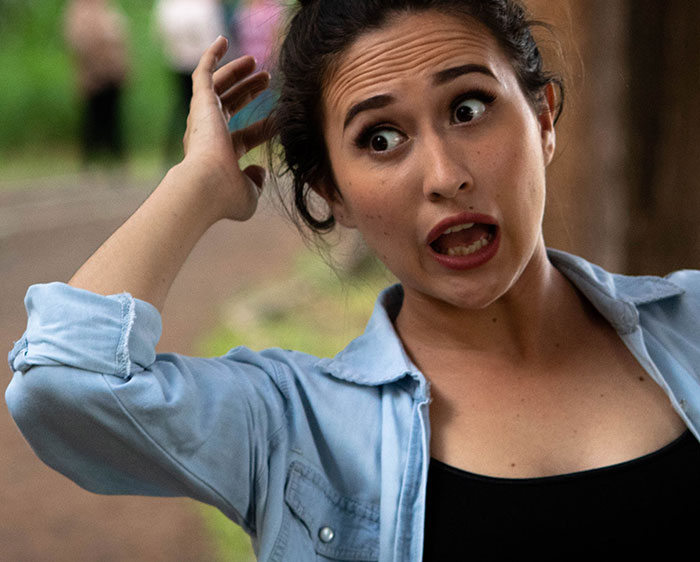 Woman talking and scratching her head 