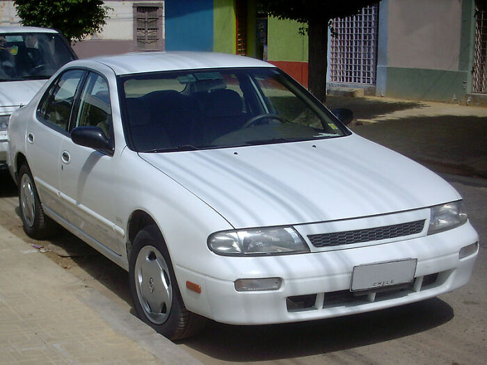White sedan parked on street with a windshield note, showcasing one of the most startling windshield notes found by people.