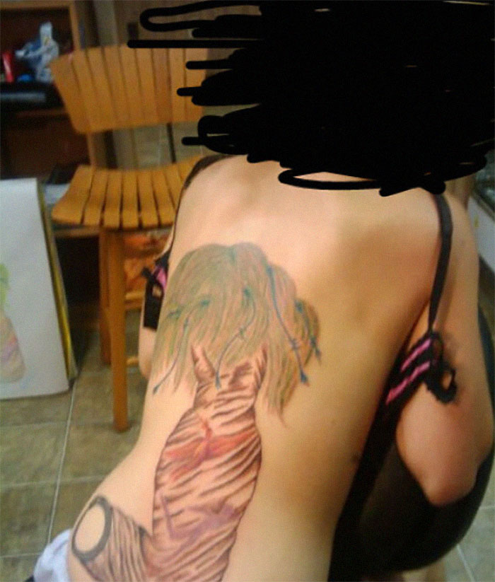Poorly executed back tattoo featuring distorted abstract design, part of an online group's collection of bad tattoos.