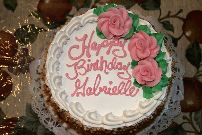 Birthday cake with pink roses and Happy Birthday Gabrielle written in pink icing, shared among startling windshield notes.